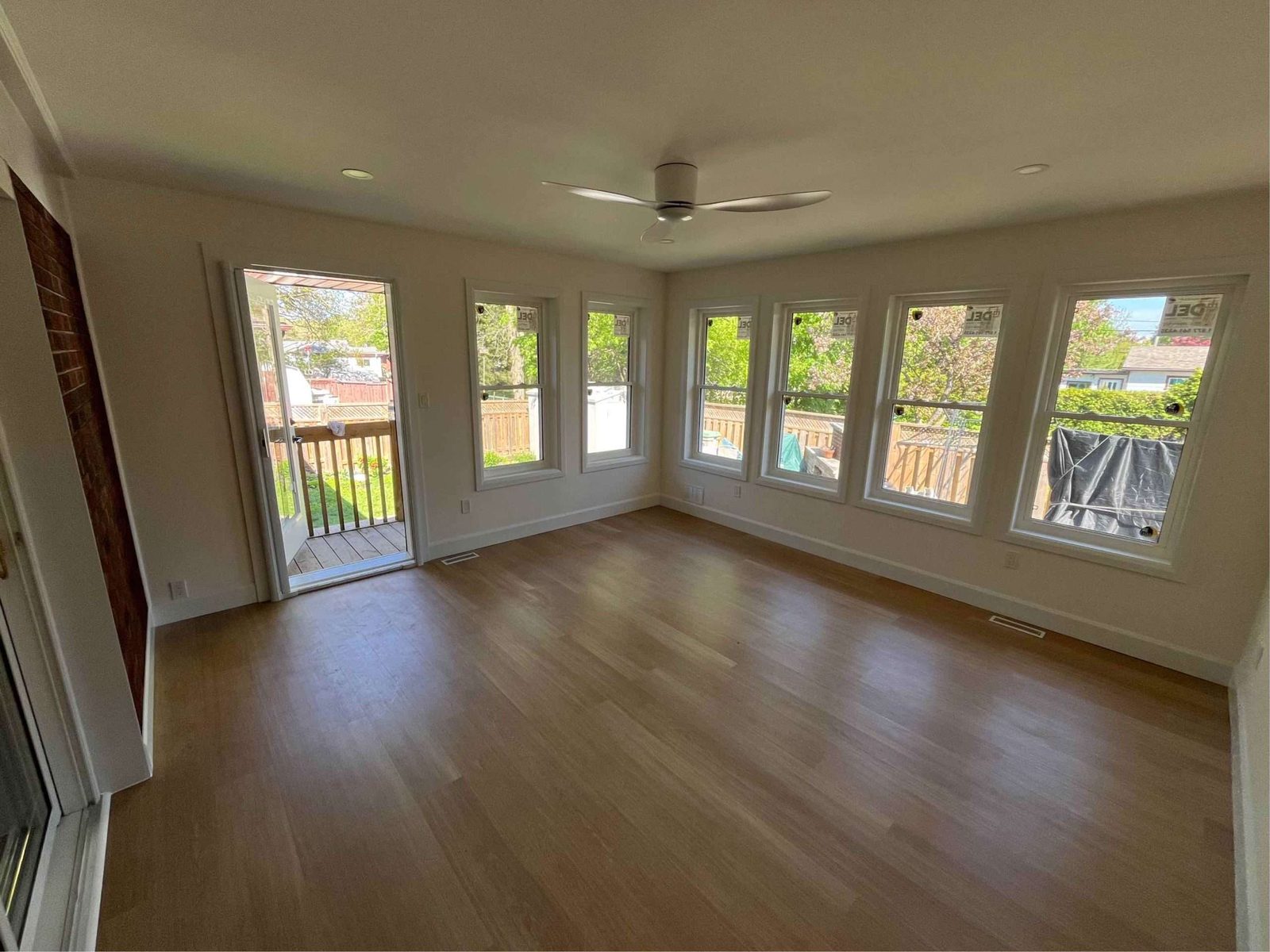 Bright sunroom addition with a wall of windows and wood flooring