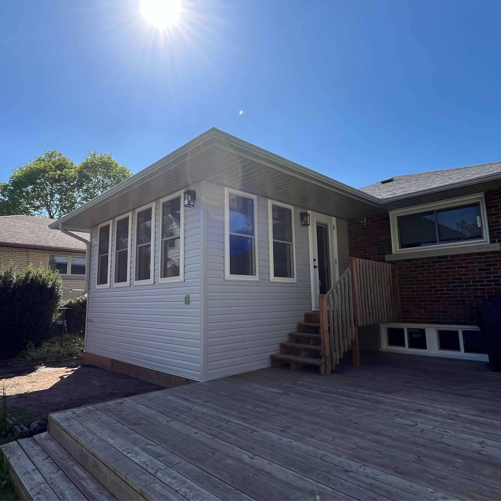 Modern home addition with a raised deck and dark trim